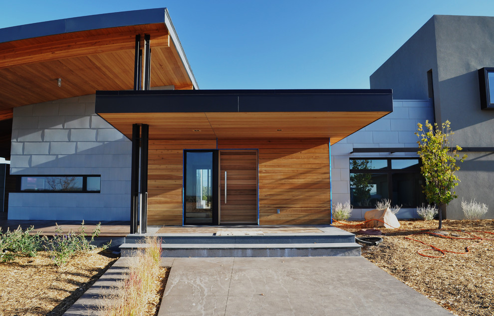 This is an example of a contemporary entryway in Denver with a single front door and a medium wood front door.