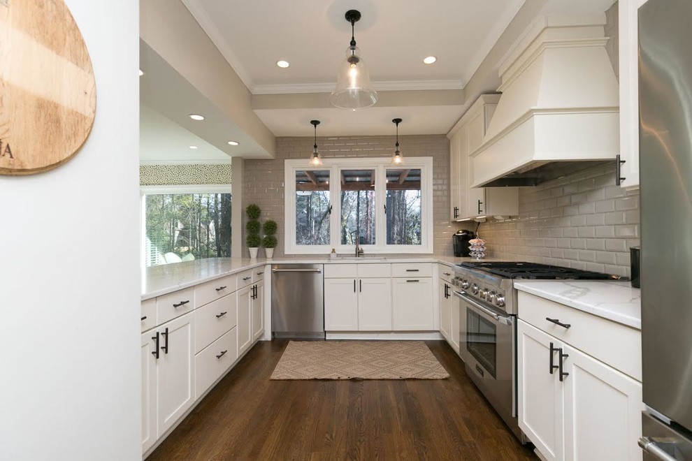 Large modern u-shaped eat-in kitchen in Atlanta with an undermount sink, recessed-panel cabinets, white cabinets, quartzite benchtops, white splashback, subway tile splashback, stainless steel appliances, a peninsula and white benchtop.
