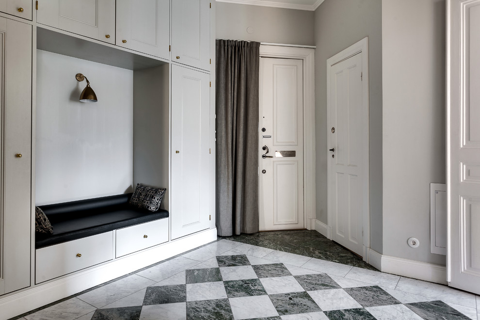 This is an example of a mid-sized traditional entryway in Stockholm with grey walls and ceramic floors.
