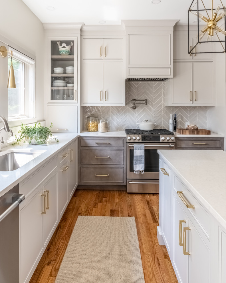 Design ideas for a medium sized traditional l-shaped kitchen in Philadelphia with a submerged sink, beige cabinets, engineered stone countertops, ceramic splashback, stainless steel appliances, an island, brown floors, white worktops, grey splashback and medium hardwood flooring.