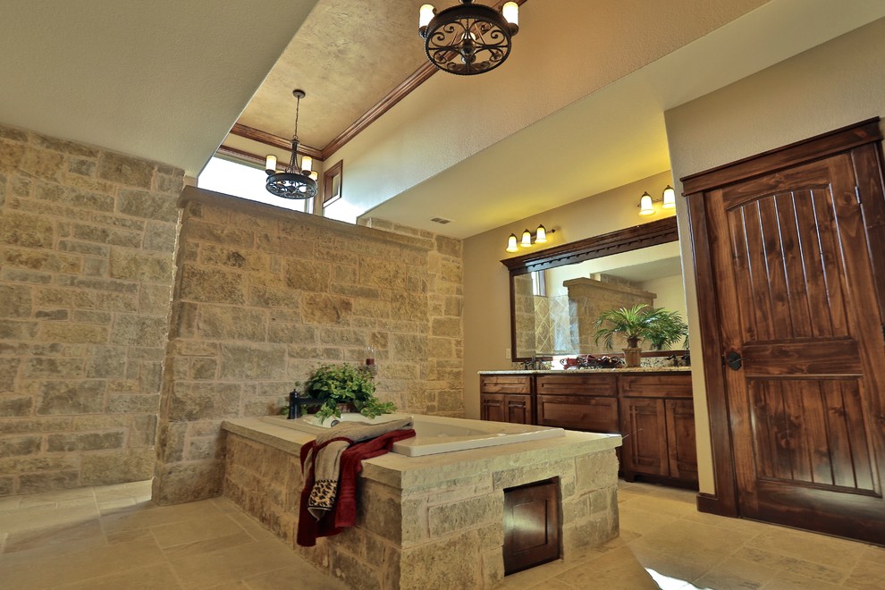 Design ideas for a large mediterranean bathroom in Dallas with an undermount sink, shaker cabinets, dark wood cabinets, granite benchtops, a drop-in tub, an open shower, a two-piece toilet, beige tile, stone tile, beige walls and travertine floors.