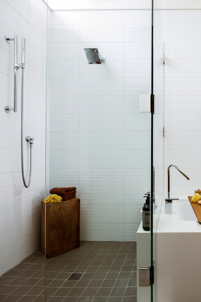 Photo of a contemporary master bathroom in Seattle with flat-panel cabinets, medium wood cabinets, an undermount tub, a corner shower, white tile, cement tile, white walls, porcelain floors, a vessel sink, solid surface benchtops, beige floor, a hinged shower door and white benchtops.