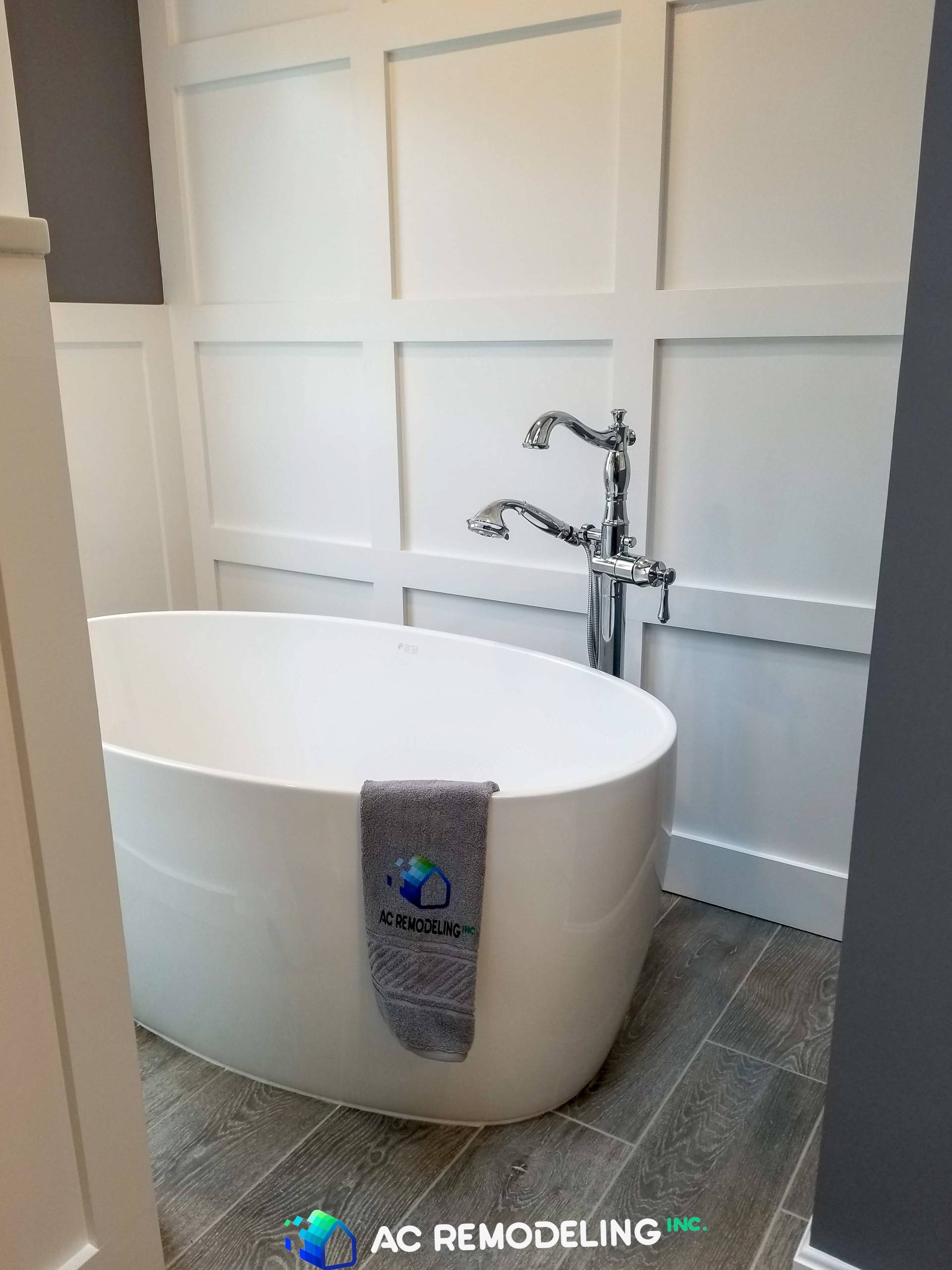 Freestanding tub and white paneling wall