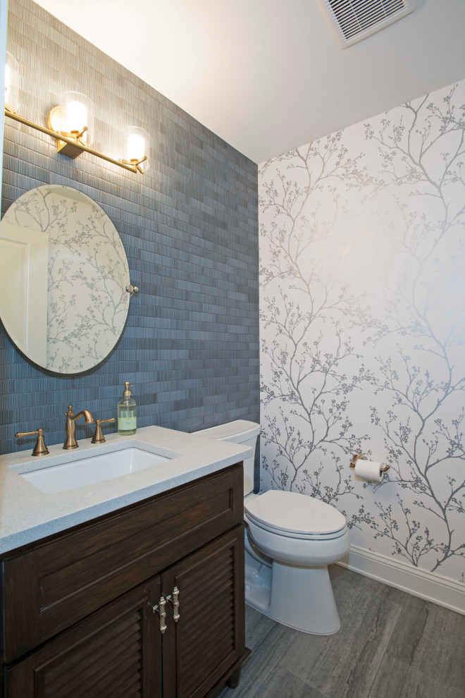 Powder room - blue tile gray floor and wallpaper powder room idea in Dallas with dark wood cabinets, white walls and white countertops