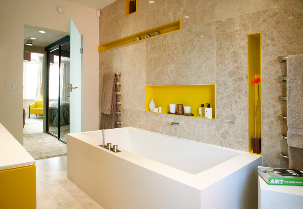This is an example of a mid-sized contemporary master bathroom in London with yellow cabinets, a freestanding tub, beige walls and beige tile.