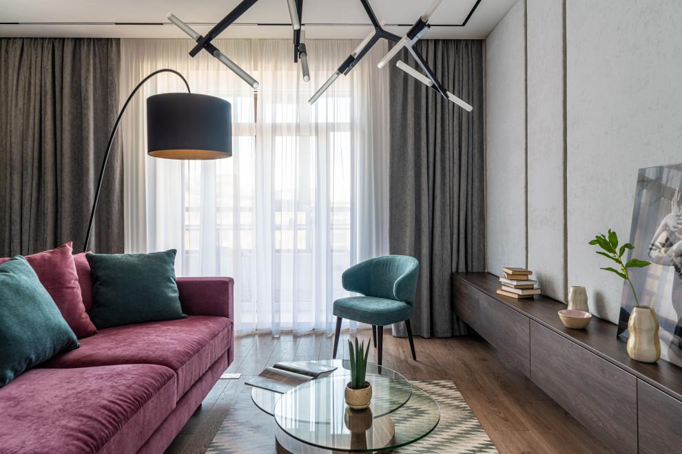 Стильный дизайн: гостиная комната среднего размера в современном стиле с серыми стенами, полом из ламината, зоной отдыха, коричневым полом, обоями на стенах и бордовым диваном - последний тренд
