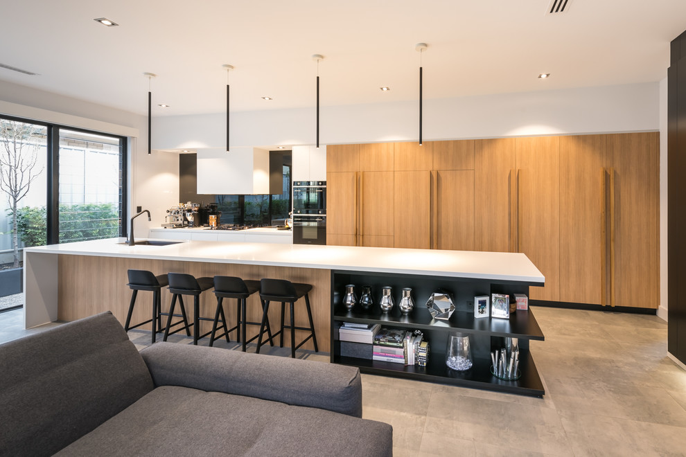 Design ideas for a large contemporary galley open plan kitchen in Adelaide with an undermount sink, flat-panel cabinets, light wood cabinets, granite benchtops, black splashback, glass sheet splashback, black appliances, ceramic floors, with island, grey floor and white benchtop.