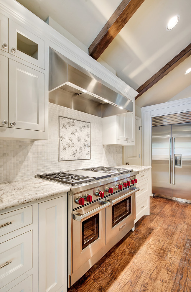 Eat-in kitchen - huge transitional l-shaped eat-in kitchen idea in Dallas with shaker cabinets, white cabinets, white backsplash, stone tile backsplash and stainless steel appliances