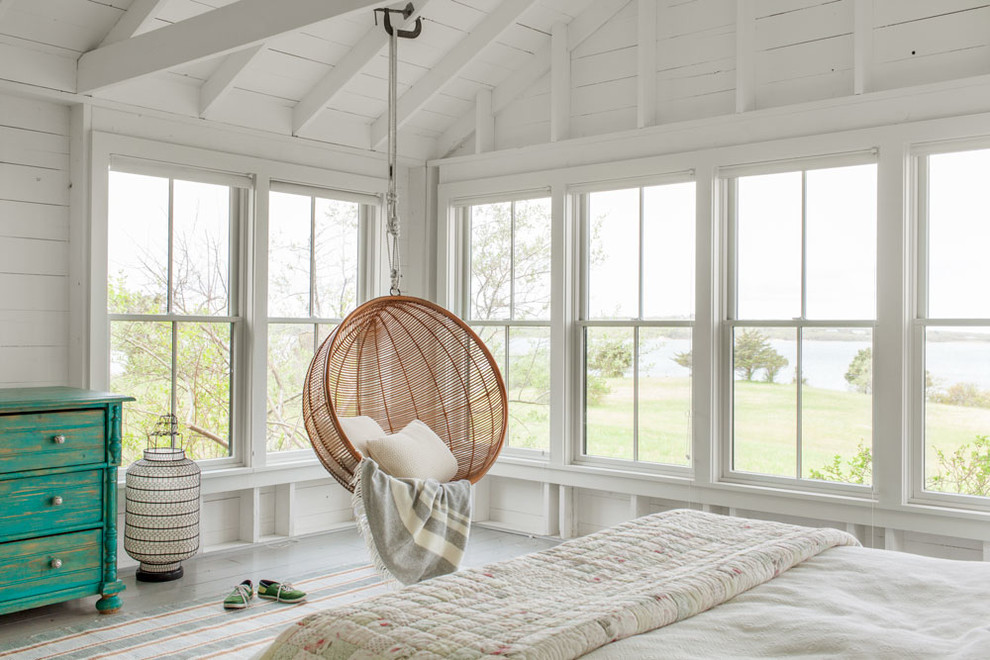 Photo of a large beach style guest bedroom in Boston with white walls and medium hardwood floors.