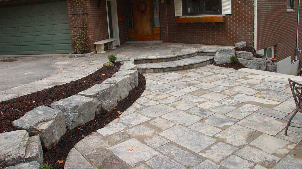 This is an example of a mid-sized traditional front yard patio in Toronto with concrete pavers and no cover.