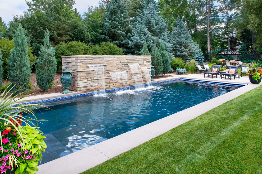 Large contemporary backyard rectangular lap pool in Denver with a water feature.
