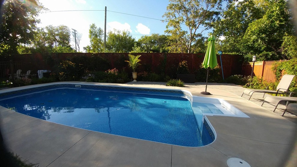 Mid-sized traditional backyard rectangular pool in Ottawa with concrete slab.