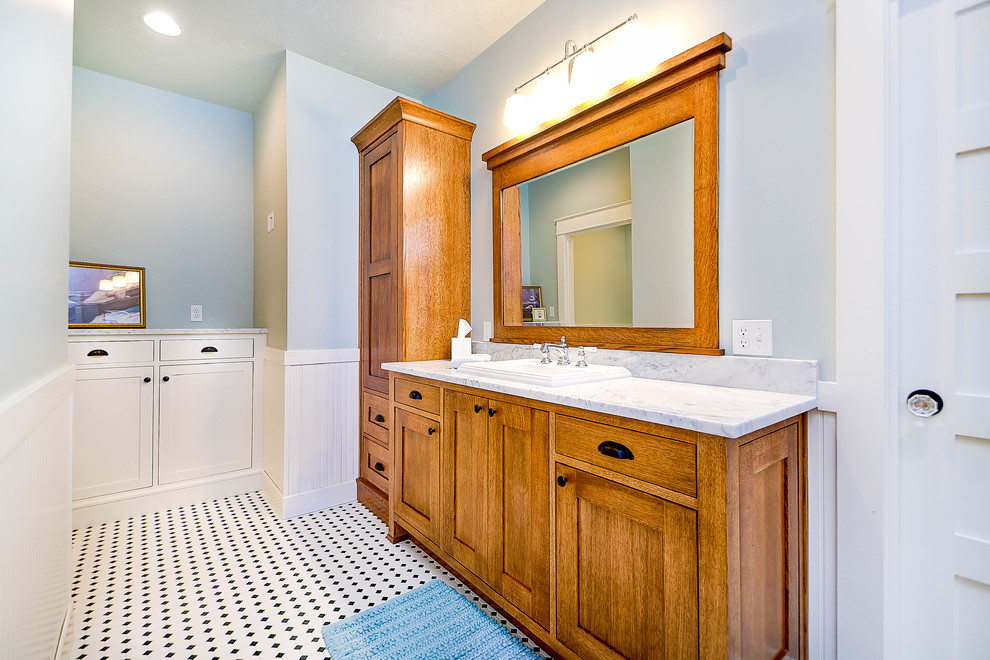 This is an example of a mid-sized arts and crafts master bathroom in Other with a drop-in sink, marble benchtops, shaker cabinets, medium wood cabinets, black and white tile, porcelain tile, blue walls and porcelain floors.