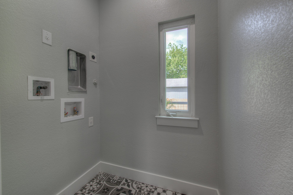 Inspiration for a mid-sized modern dedicated laundry room in Austin with grey walls, ceramic floors, a stacked washer and dryer and grey floor.