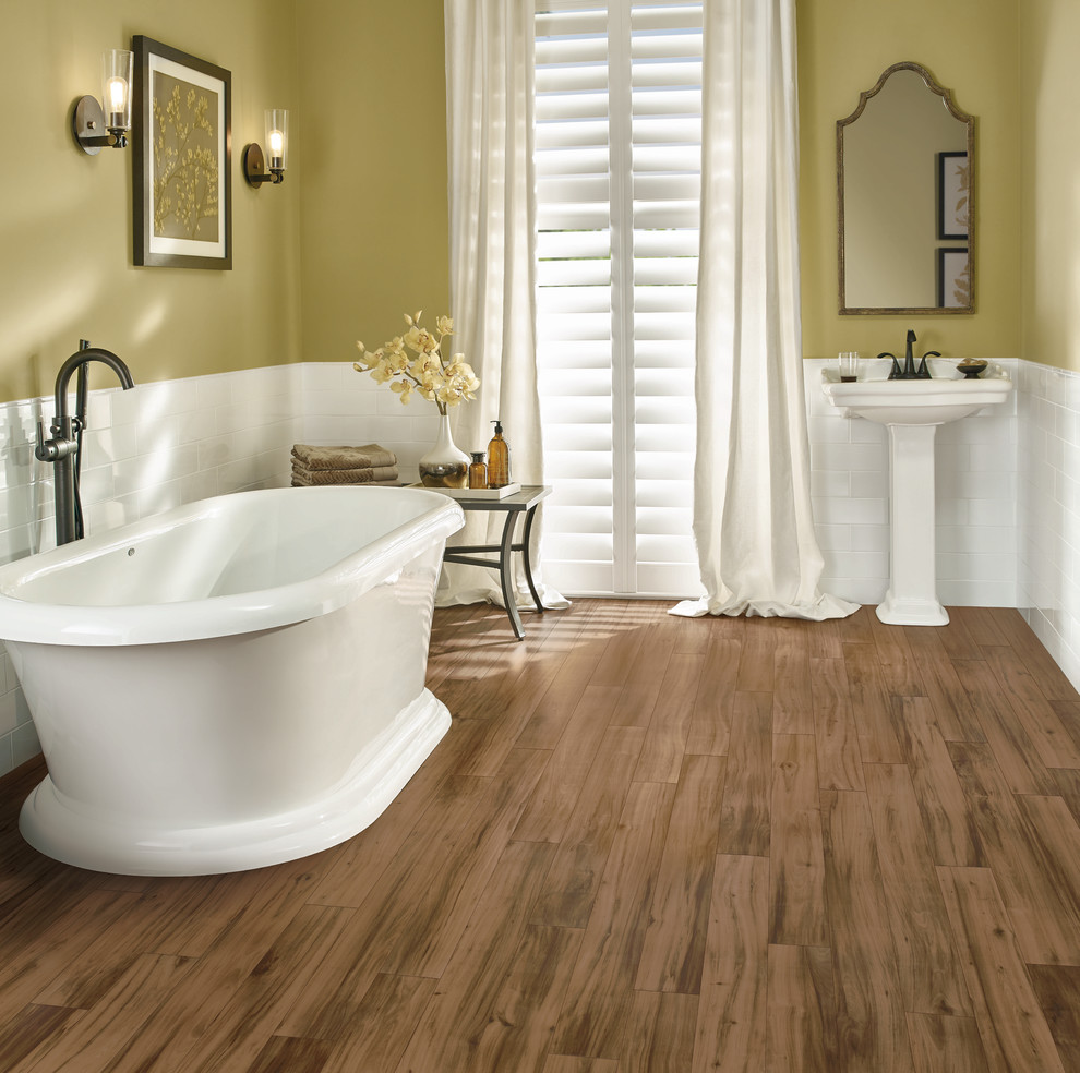 Inspiration for a mid-sized transitional 3/4 bathroom in Other with a freestanding tub, yellow walls, vinyl floors, a pedestal sink and brown floor.