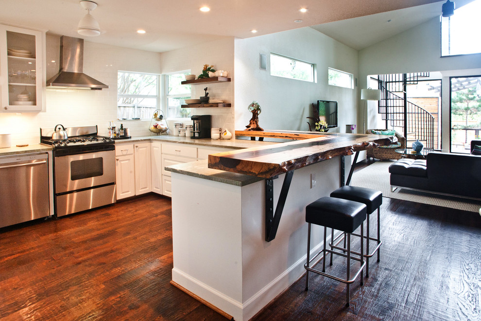 Inspiration for a mid-sized modern u-shaped eat-in kitchen in Dallas with a single-bowl sink, raised-panel cabinets, white cabinets, white splashback, subway tile splashback, stainless steel appliances, dark hardwood floors, a peninsula and brown floor.