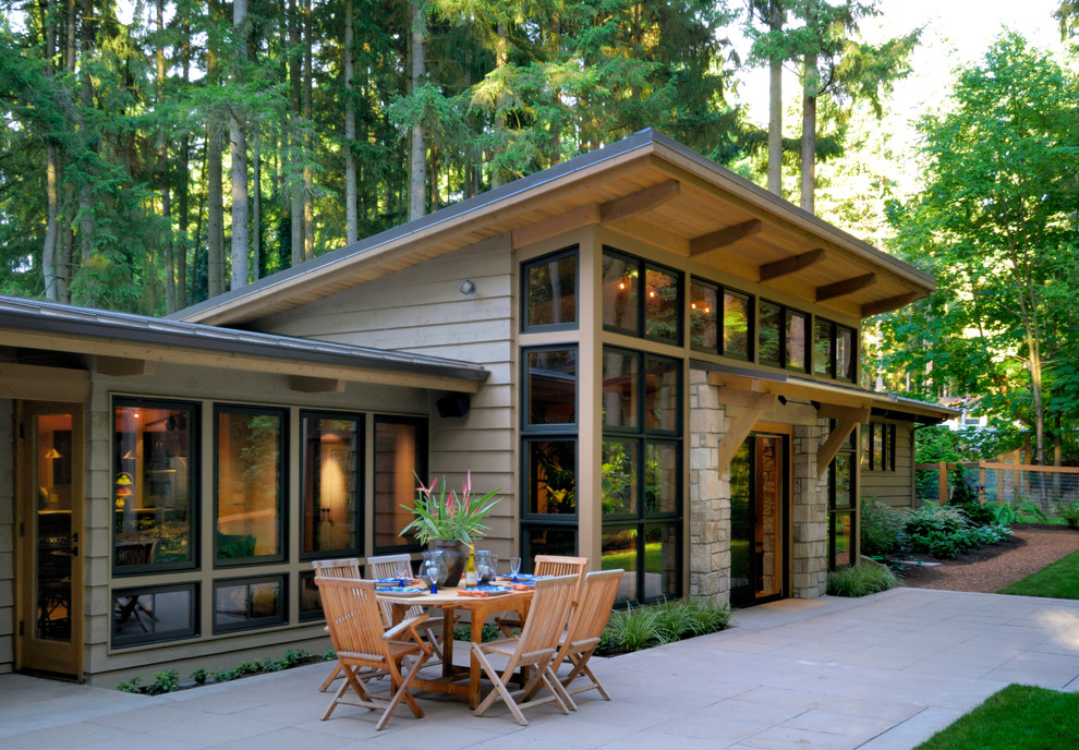 Large arts and crafts two-storey grey house exterior in Seattle with a shed roof and mixed siding.