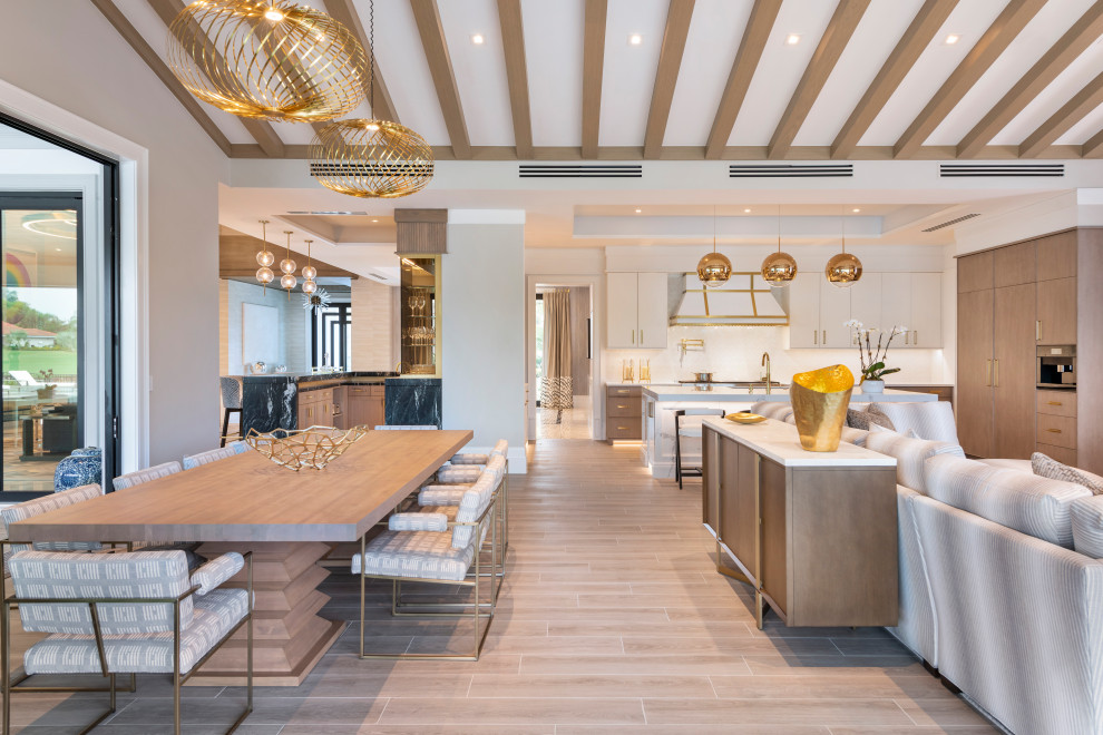 Inspiration for an expansive u-shaped open plan kitchen in Miami with flat-panel cabinets, white cabinets, marble benchtops, porcelain floors, with island, beige floor and white benchtop.