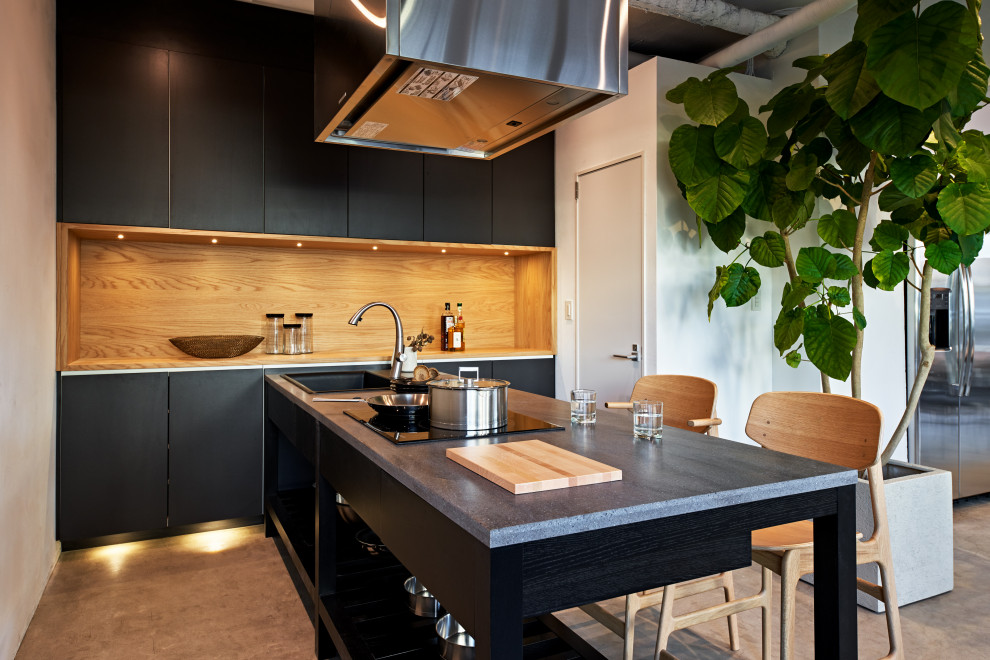 Ispirazione per una cucina moderna di medie dimensioni con ante nere, elettrodomestici neri, top in superficie solida e top nero