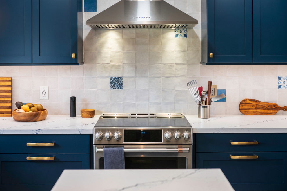 Photo of a large eclectic u-shaped eat-in kitchen in San Luis Obispo with a farmhouse sink, shaker cabinets, blue cabinets, quartz benchtops, white splashback, ceramic splashback, stainless steel appliances, porcelain floors, with island, beige floor and white benchtop.