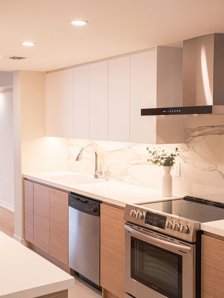 This is an example of a small modern galley kitchen/diner in Toronto with a submerged sink, light wood cabinets, engineered stone countertops, white splashback, stainless steel appliances, no island, white worktops, flat-panel cabinets, porcelain flooring, grey floors and porcelain splashback.