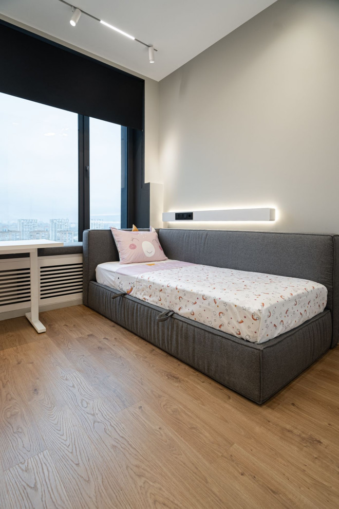 This is an example of a mid-sized contemporary kids' bedroom for kids 4-10 years old and girls in Other with grey walls and dark hardwood floors.