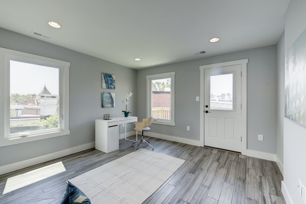 Photo of a mid-sized transitional home office in DC Metro with grey walls, bamboo floors, a freestanding desk and grey floor.