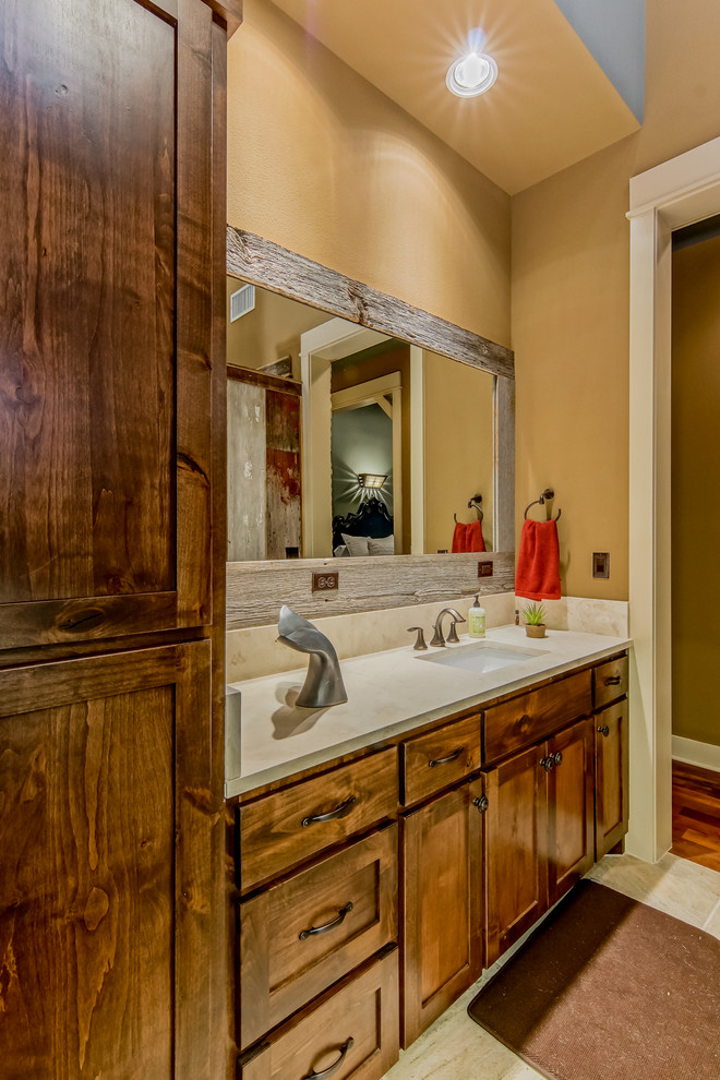 Photo of a country bathroom in Austin with an undermount sink, shaker cabinets, medium wood cabinets and beige walls.