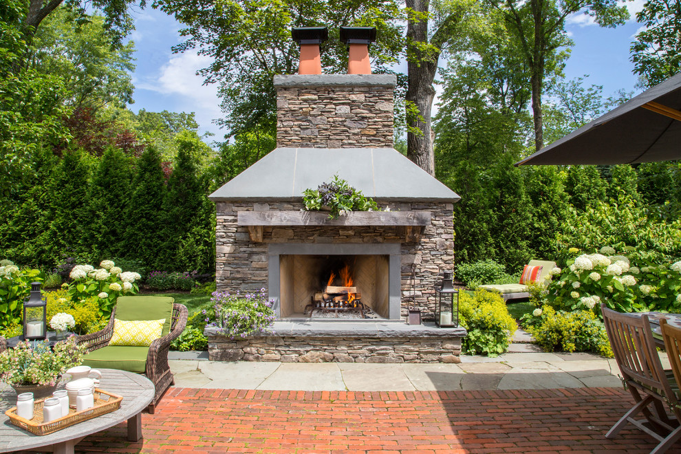 Design ideas for a large arts and crafts backyard patio in Chicago with natural stone pavers, no cover and a fire feature.