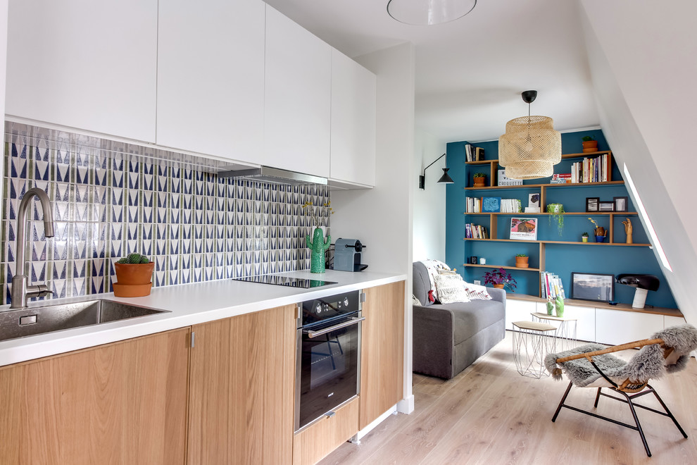 Design ideas for a contemporary single-wall open plan kitchen in Paris with a drop-in sink, flat-panel cabinets, medium wood cabinets, multi-coloured splashback, stainless steel appliances, light hardwood floors, no island and beige floor.