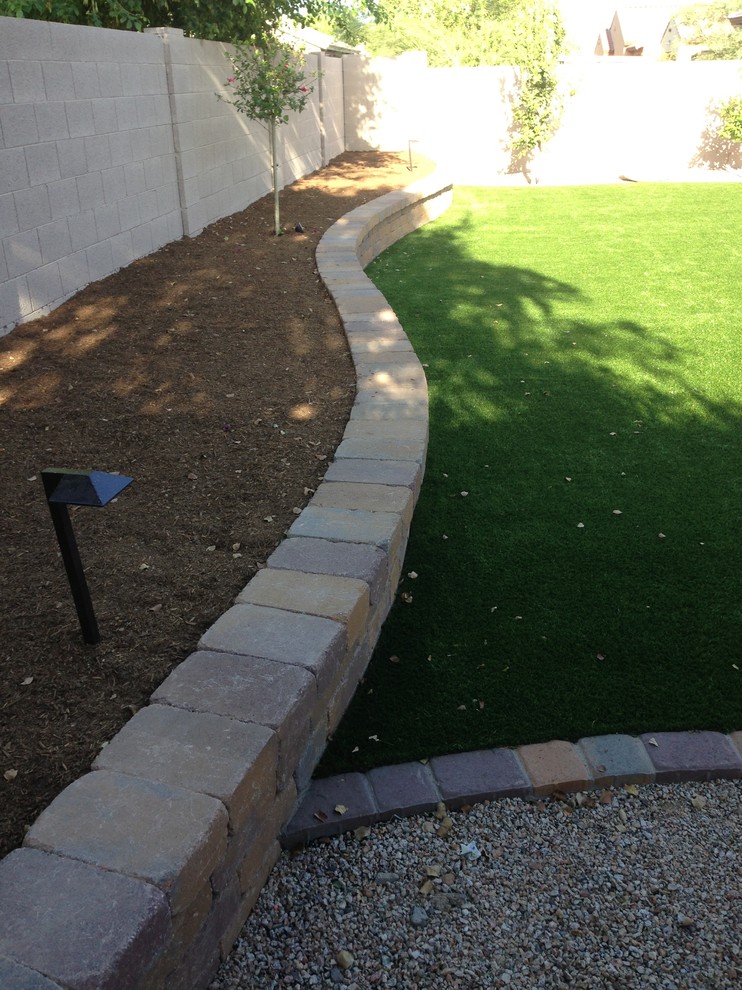 Inspiration for a mid-sized backyard garden in Phoenix with a retaining wall and concrete pavers.