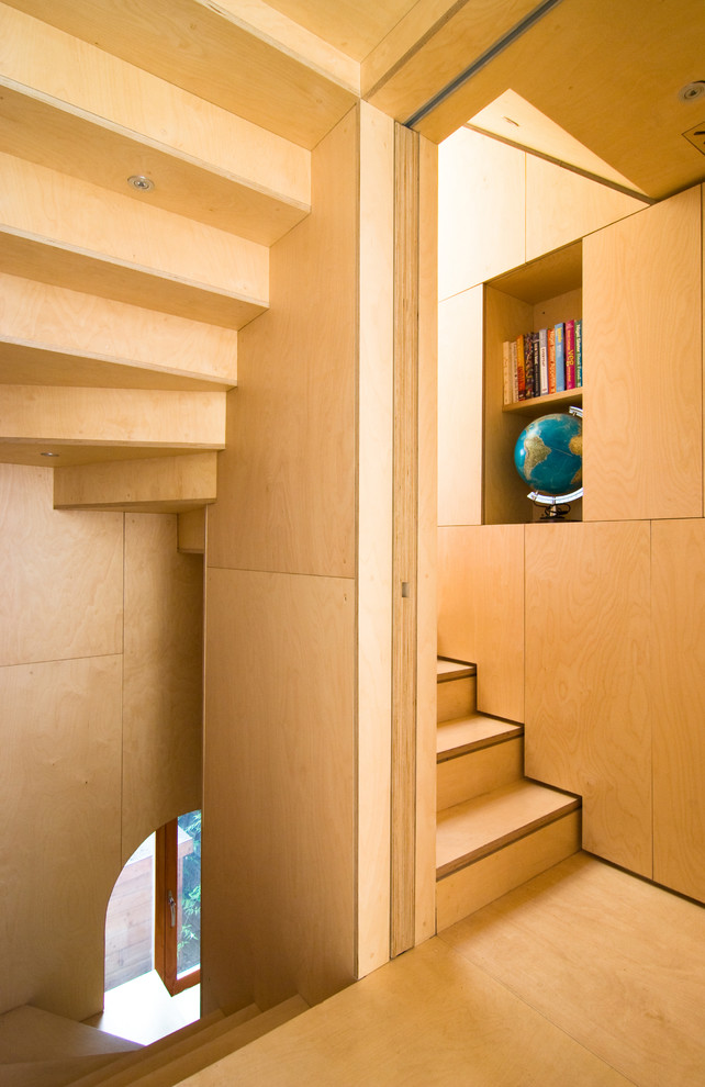Photo of a small contemporary wood u-shaped staircase in London with wood risers.