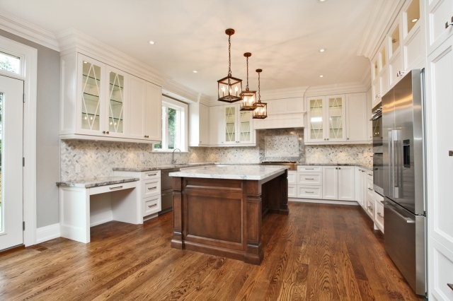 Mid-sized transitional u-shaped medium tone wood floor open concept kitchen photo in Toronto with an undermount sink, recessed-panel cabinets, white cabinets, marble countertops, gray backsplash, stone slab backsplash, stainless steel appliances and an island