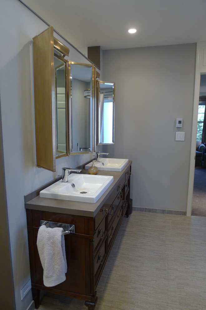 Large transitional master gray tile and porcelain tile porcelain tile freestanding bathtub photo in Indianapolis with a drop-in sink, furniture-like cabinets, dark wood cabinets, solid surface countertops, a one-piece toilet and gray walls