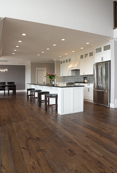 Open concept kitchen - transitional galley medium tone wood floor open concept kitchen idea in Vancouver with an undermount sink, shaker cabinets, white cabinets, quartzite countertops, multicolored backsplash, mosaic tile backsplash, stainless steel appliances and an island
