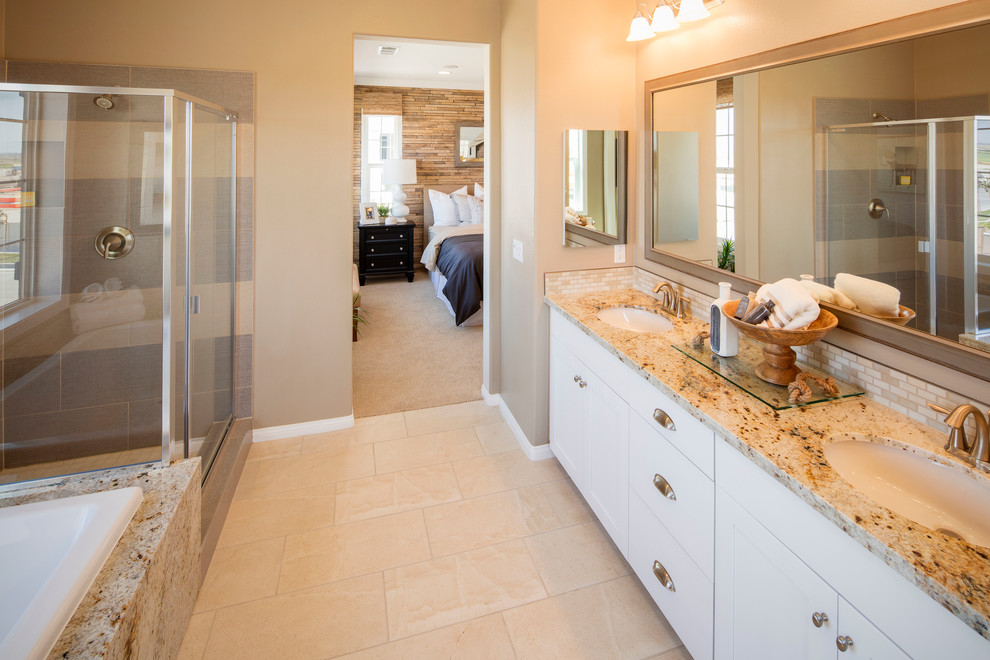 Mid-sized beach style master bathroom in Los Angeles with limestone floors, a drop-in tub, a corner shower, engineered quartz benchtops, flat-panel cabinets, white cabinets, gray tile, porcelain tile, beige walls, an undermount sink, beige floor and a hinged shower door.