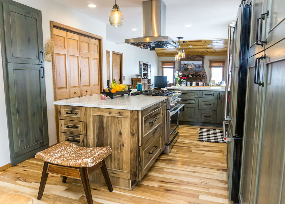 Open concept kitchen - large rustic light wood floor and brown floor open concept kitchen idea with beaded inset cabinets, distressed cabinets, granite countertops, an island and white countertops