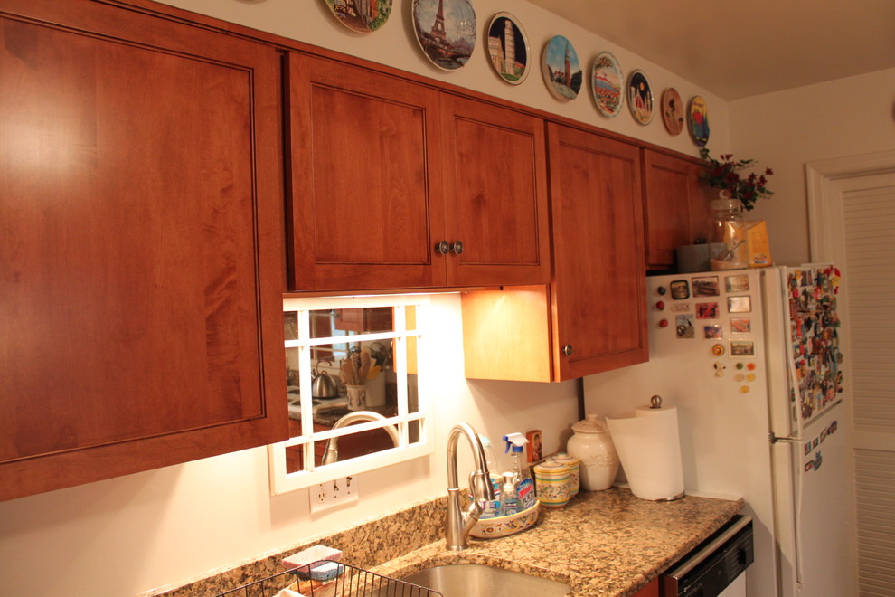 Eat-in kitchen - transitional l-shaped linoleum floor eat-in kitchen idea in Baltimore with an undermount sink, recessed-panel cabinets, medium tone wood cabinets, granite countertops, white backsplash, white appliances and no island
