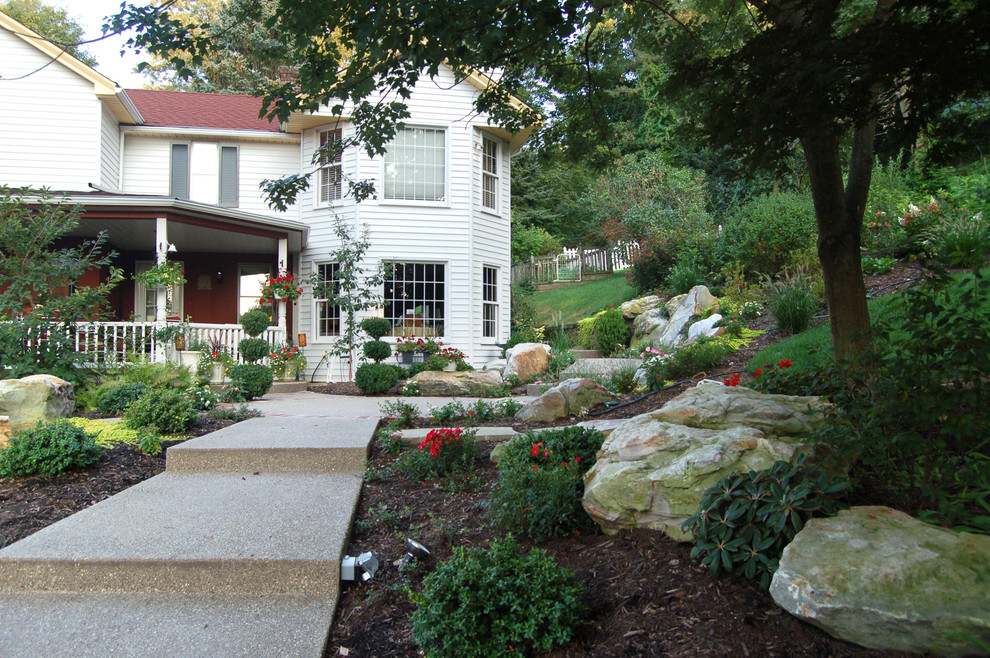 Mid-sized traditional front yard full sun formal garden in Other with a garden path and gravel for summer.
