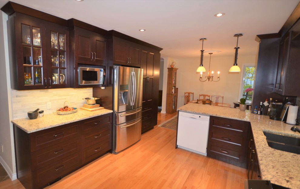 Eat-in kitchen - mid-sized transitional galley medium tone wood floor and brown floor eat-in kitchen idea in Ottawa with recessed-panel cabinets, dark wood cabinets, granite countertops, gray backsplash, stainless steel appliances, a double-bowl sink, porcelain backsplash, a peninsula and beige countertops