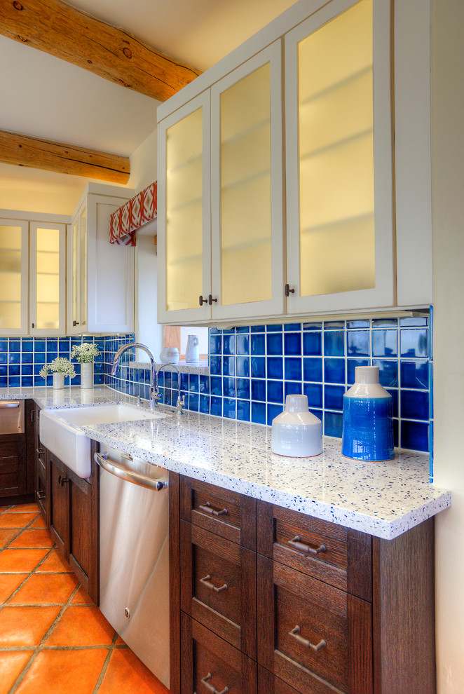 Large l-shaped eat-in kitchen in Phoenix with a farmhouse sink, shaker cabinets, dark wood cabinets, recycled glass benchtops, blue splashback, ceramic splashback, stainless steel appliances, terra-cotta floors and with island.
