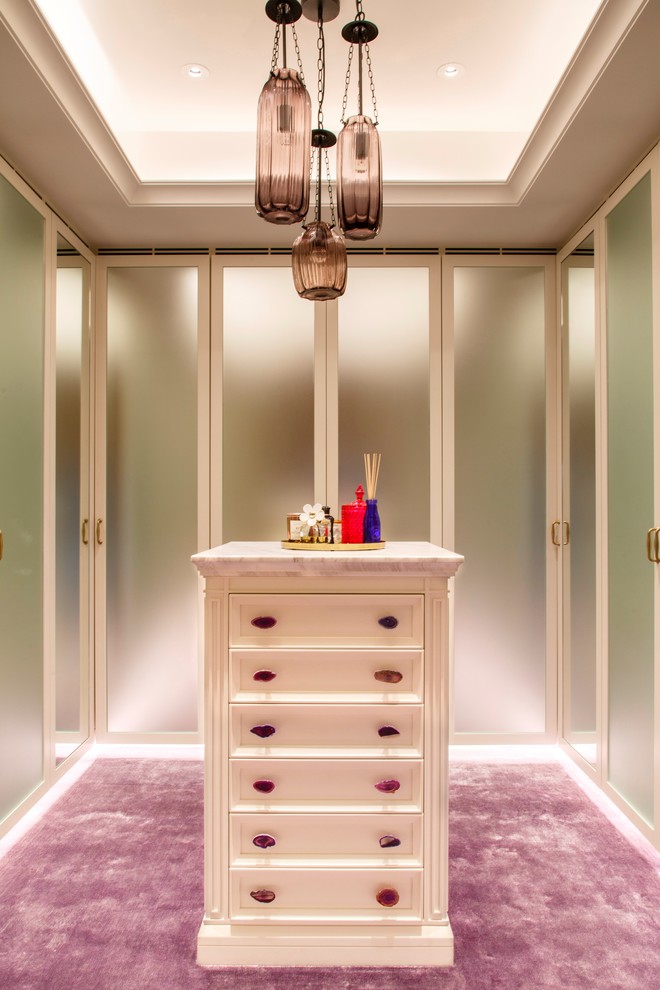 This is an example of a mid-sized contemporary gender-neutral walk-in wardrobe in Hong Kong with flat-panel cabinets, carpet and purple floor.