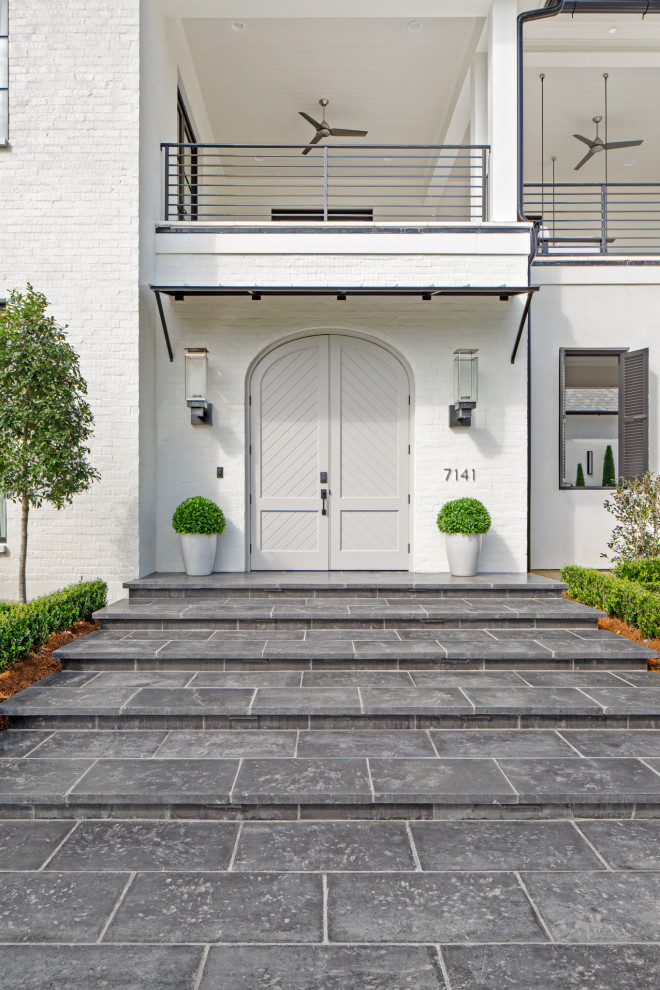 This is an example of a contemporary front door in New Orleans with concrete floors, a double front door, a gray front door and black floor.
