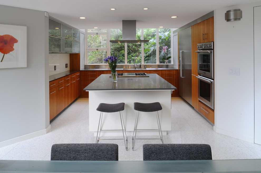 This is an example of a contemporary u-shaped eat-in kitchen in San Francisco with a double-bowl sink, flat-panel cabinets, medium wood cabinets, grey splashback, metal splashback, stainless steel appliances, porcelain floors and with island.