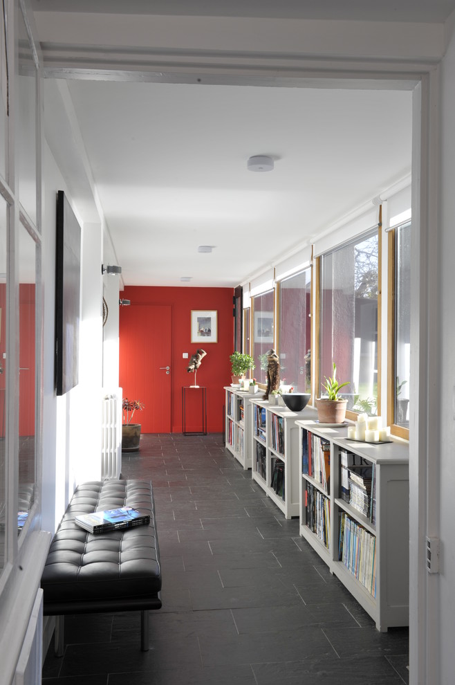 Large contemporary hallway in Rennes with white walls and slate floors.