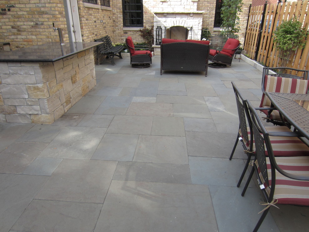 Photo of a mid-sized transitional backyard patio in Chicago with stamped concrete and no cover.