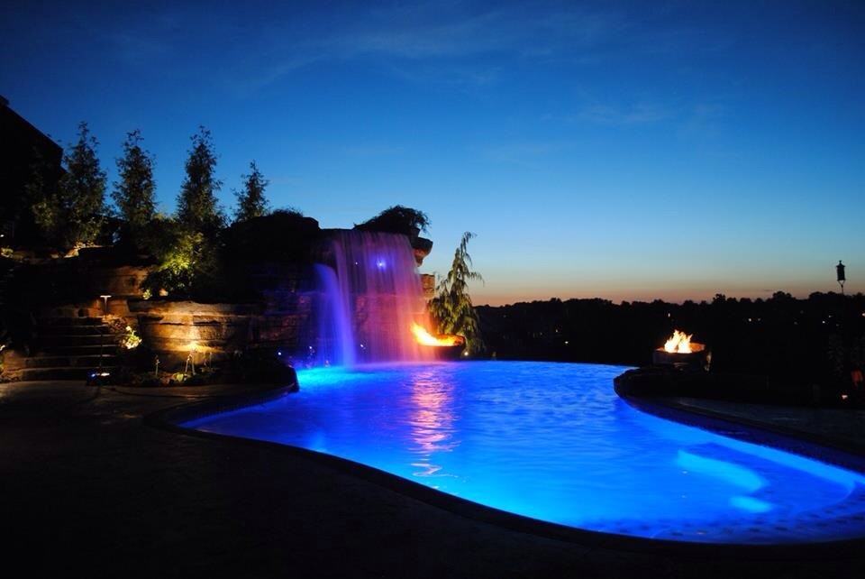 Large mountain style backyard stamped concrete and custom-shaped natural pool fountain photo