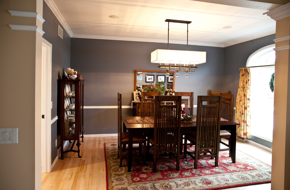 Example of a large transitional light wood floor and brown floor enclosed dining room design with gray walls and no fireplace
