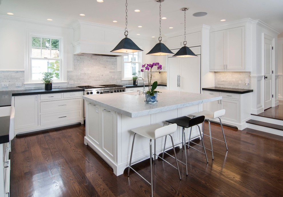 Inspiration for a traditional u-shaped kitchen in San Francisco with an undermount sink, shaker cabinets, white splashback, stainless steel appliances, dark hardwood floors and with island.