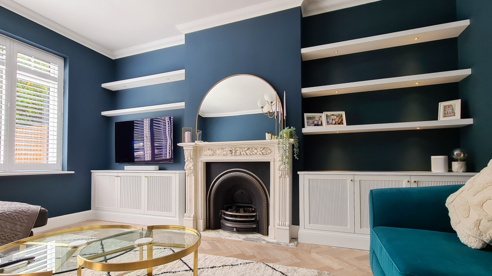 Источник вдохновения для домашнего уюта: гостиная комната среднего размера в стиле модернизм с синими стенами, полом из ламината, стандартным камином, фасадом камина из камня, мультимедийным центром и коричневым полом